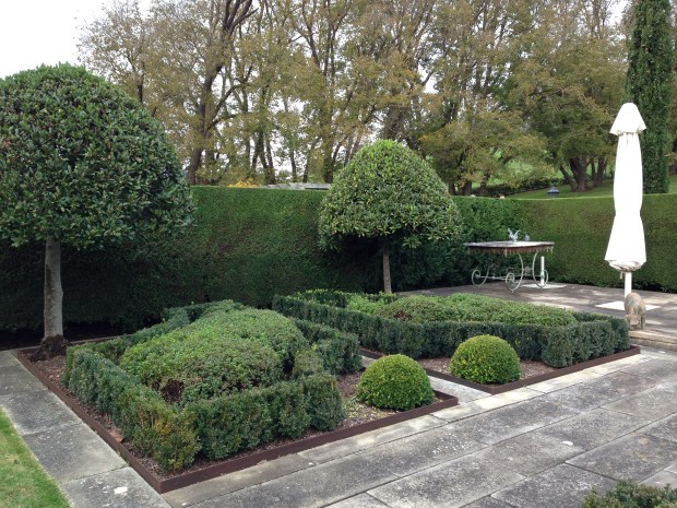 Buxus parterre and pruned bay trees at the rear of the house