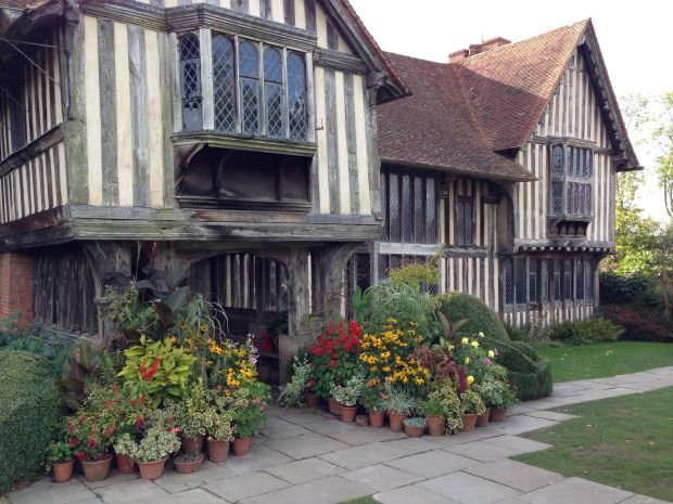 Massed, eclectic collection of potted plants at the front entrance to the Great Dixter house