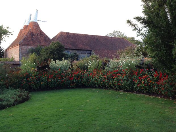 Hot orange and red perennial border near the entrance to Great Dixter