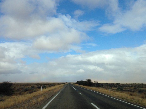 Rainbow to the left of the road, red dust to the right. Janna Schreier
